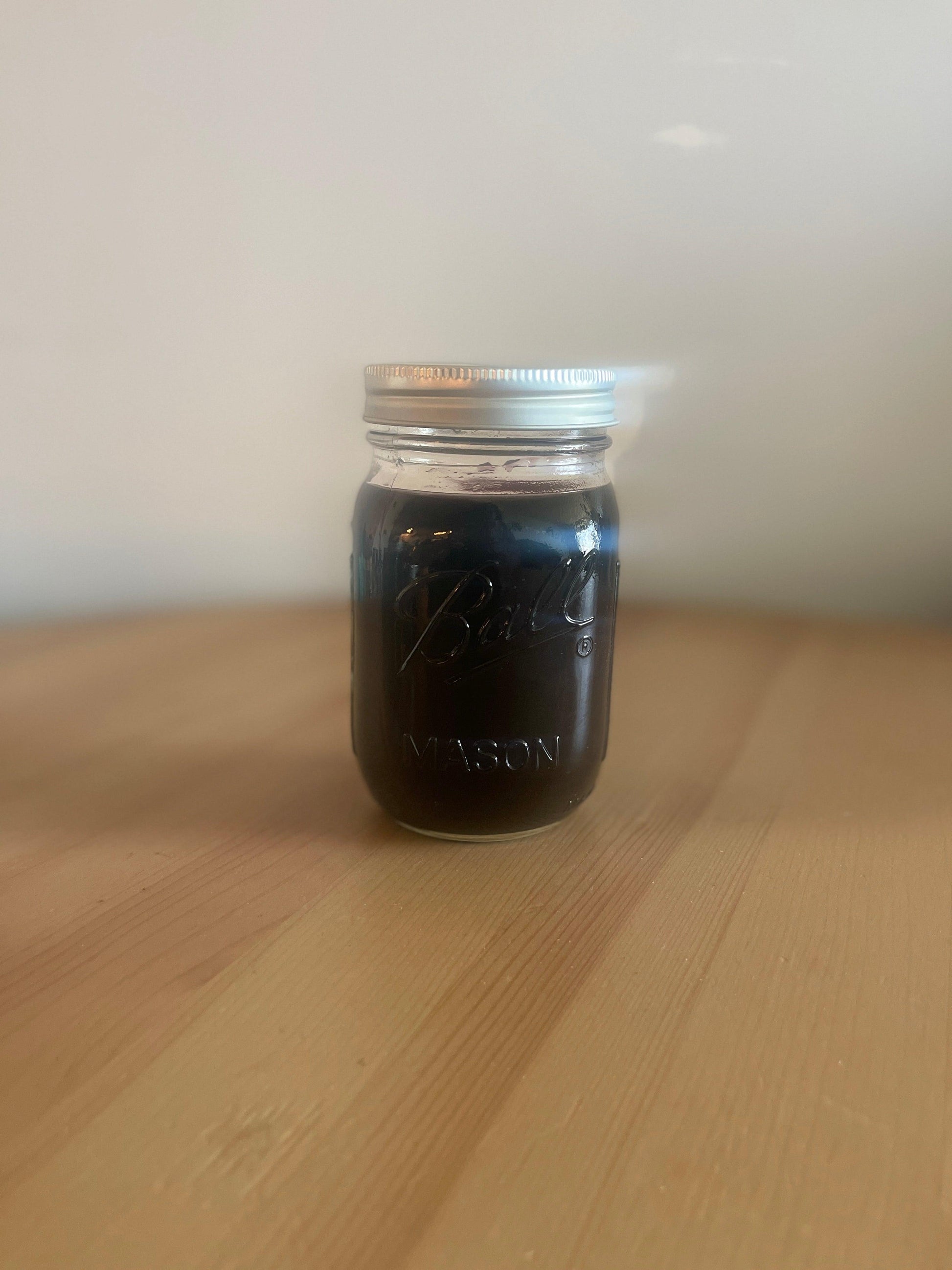 Photo of a bottle of all-natural Elderberry Syrup with organic agave nectar, a natural sweetener, available in 4oz, 8oz, and 16oz bottles, perfect for daily immune support during the change of season and allergy season